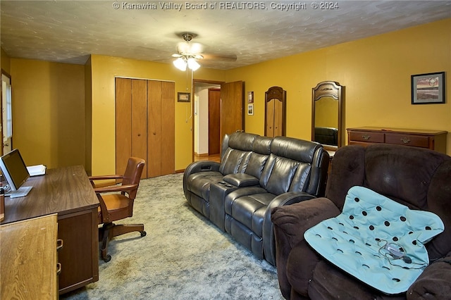 carpeted cinema room with a textured ceiling and ceiling fan