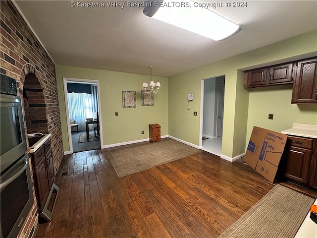 kitchen featuring dark brown cabinets, dark hardwood / wood-style floors, an inviting chandelier, and hanging light fixtures