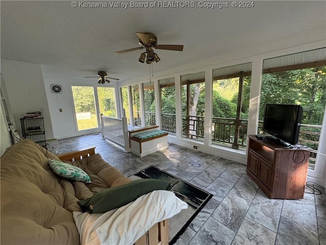 103 Central Ave, Logan, WV 25601 - living area featuring healthy amount of natural light, a ceiling fan, and stone tile floors
