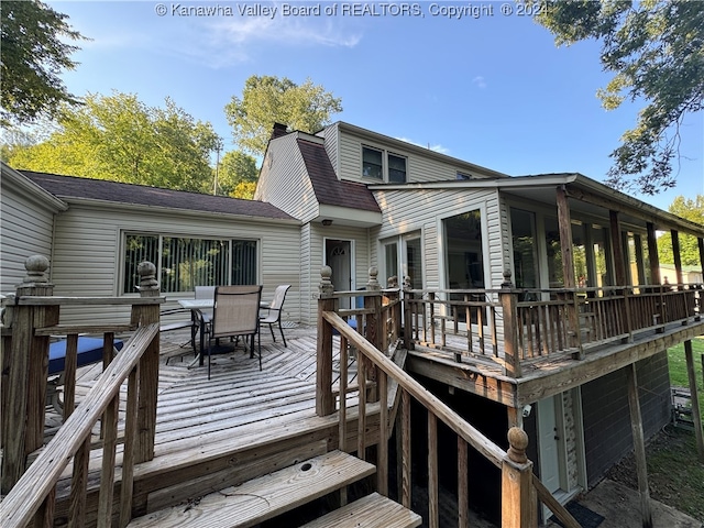 rear view of property featuring a wooden deck