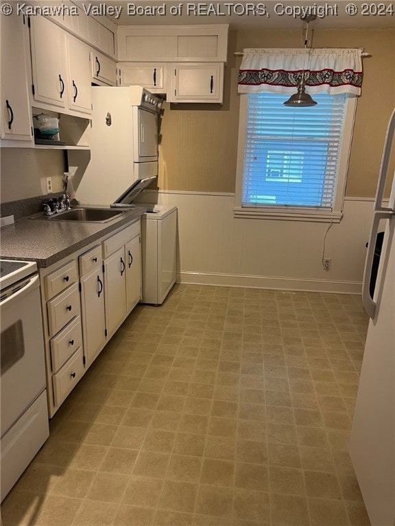 kitchen with white range with electric stovetop, white cabinetry, and stacked washer / dryer