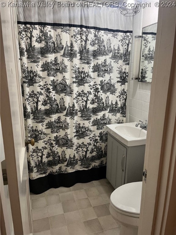 bathroom with vanity, tile walls, and toilet