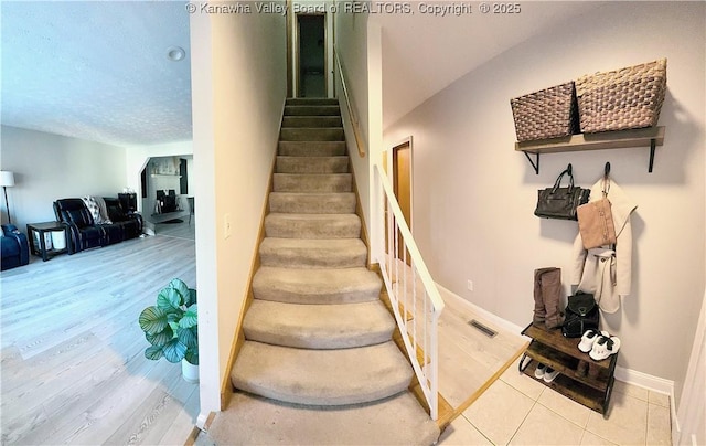 stairway with vaulted ceiling and hardwood / wood-style flooring