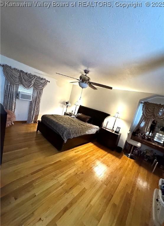 bedroom featuring a textured ceiling, ceiling fan, and wood-type flooring