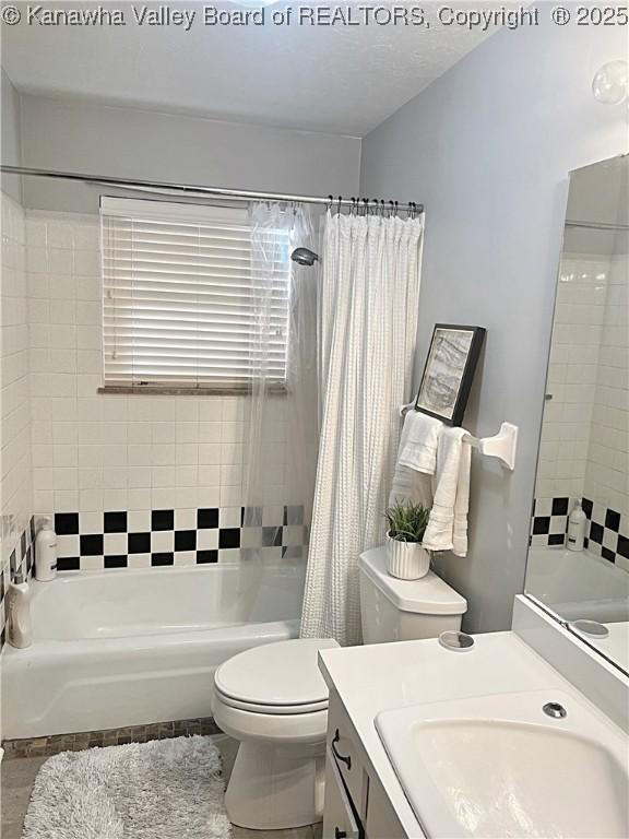 full bathroom with toilet, vanity, and shower / tub combo