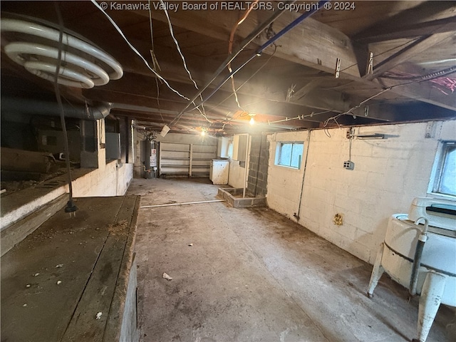 basement featuring electric panel and gas water heater