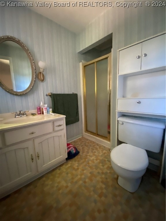 bathroom with toilet, vanity, and walk in shower