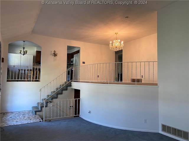 spare room featuring carpet and an inviting chandelier