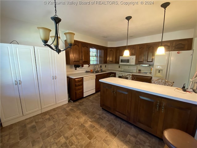 kitchen featuring white appliances, sink, hanging light fixtures, a notable chandelier, and dark brown cabinetry