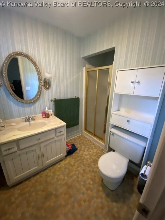 bathroom featuring vanity, an enclosed shower, and toilet