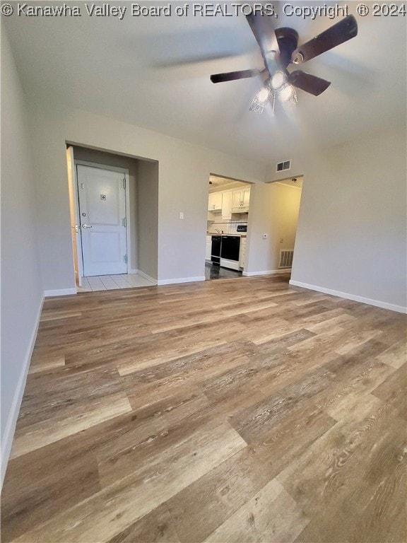 unfurnished living room featuring ceiling fan and light hardwood / wood-style flooring