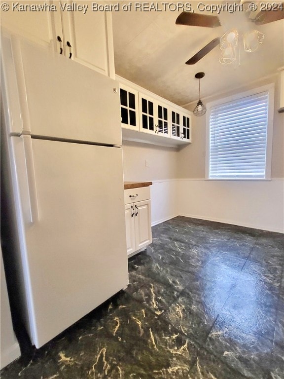 kitchen featuring white cabinetry, white fridge, decorative light fixtures, and ceiling fan