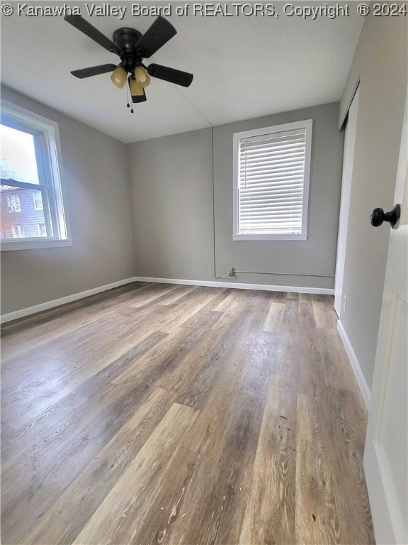 empty room with light wood-type flooring and ceiling fan