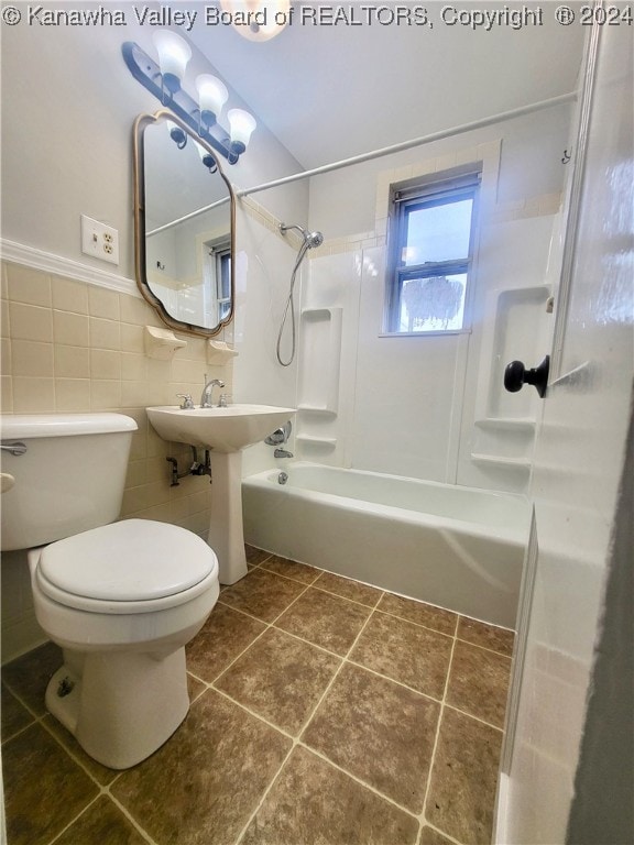 bathroom with tile patterned floors, bathtub / shower combination, tile walls, and toilet