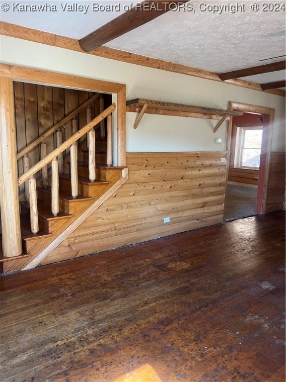 interior space with wood-type flooring, a textured ceiling, and wooden walls