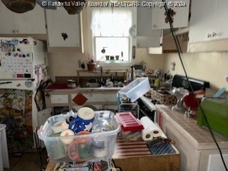 kitchen with white fridge and white cabinetry