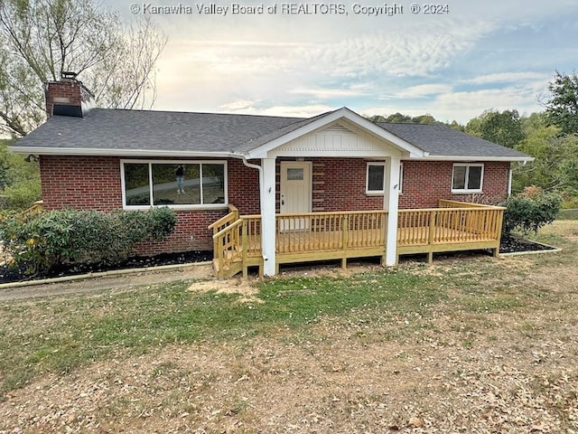 ranch-style house with a wooden deck and a front yard