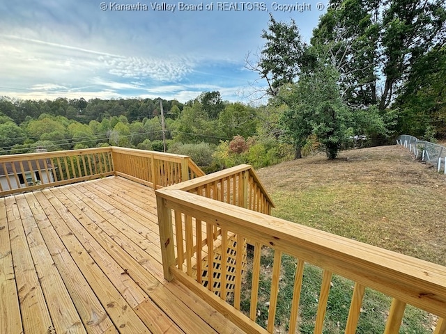 wooden deck featuring a lawn