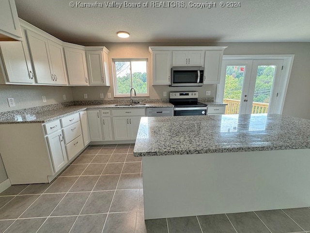 kitchen with french doors, white cabinets, a healthy amount of sunlight, and appliances with stainless steel finishes