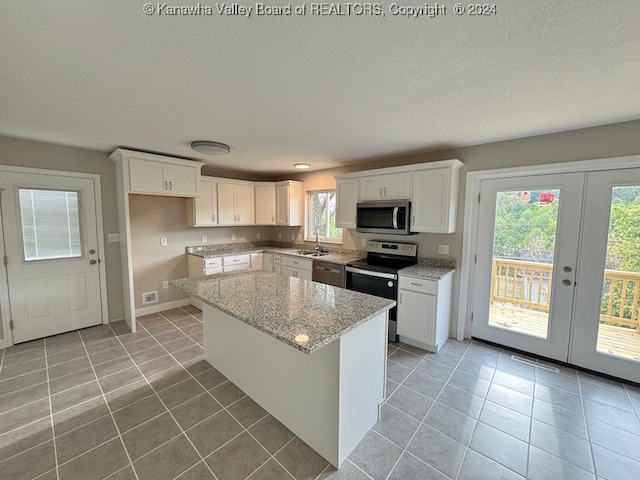 kitchen featuring white cabinets, a wealth of natural light, sink, and appliances with stainless steel finishes