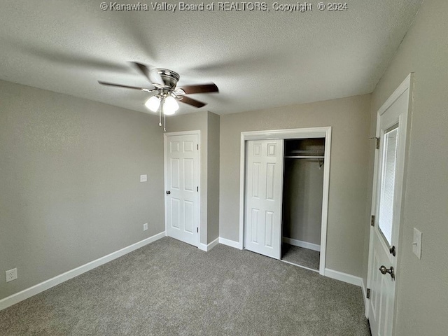 unfurnished bedroom featuring carpet, a textured ceiling, a closet, and ceiling fan