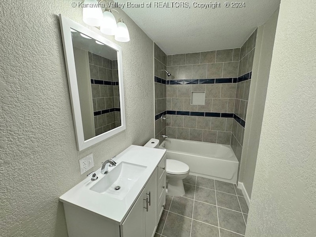 full bathroom with tile patterned floors, a textured ceiling, toilet, vanity, and tiled shower / bath