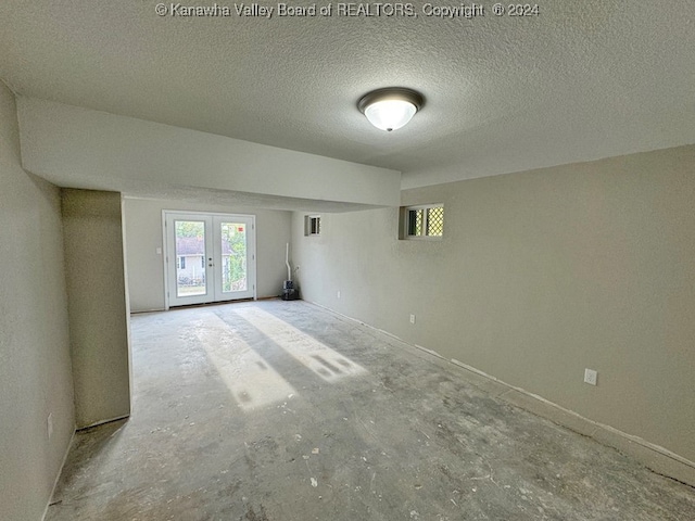 unfurnished room featuring french doors and a textured ceiling