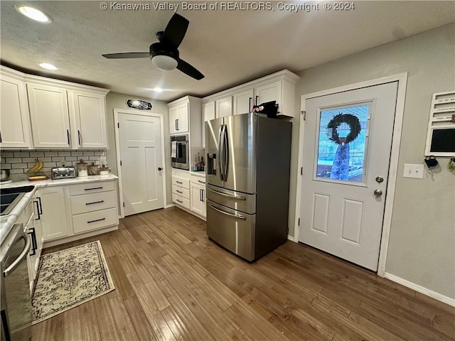 kitchen featuring dark hardwood / wood-style floors, white cabinetry, and appliances with stainless steel finishes