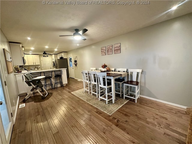 dining space with dark hardwood / wood-style floors, ceiling fan, and a textured ceiling