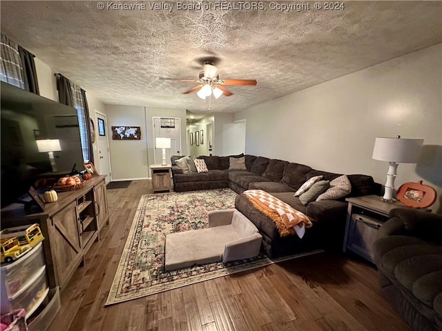 living room featuring a textured ceiling, ceiling fan, and dark hardwood / wood-style floors