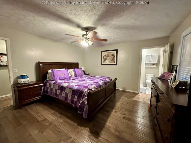 bedroom featuring a textured ceiling, ceiling fan, dark wood-type flooring, and connected bathroom