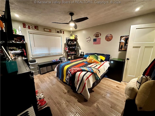 bedroom featuring light wood-type flooring, a textured ceiling, and ceiling fan