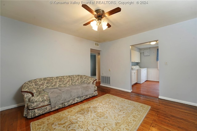 living room with hardwood / wood-style flooring, ceiling fan, and independent washer and dryer