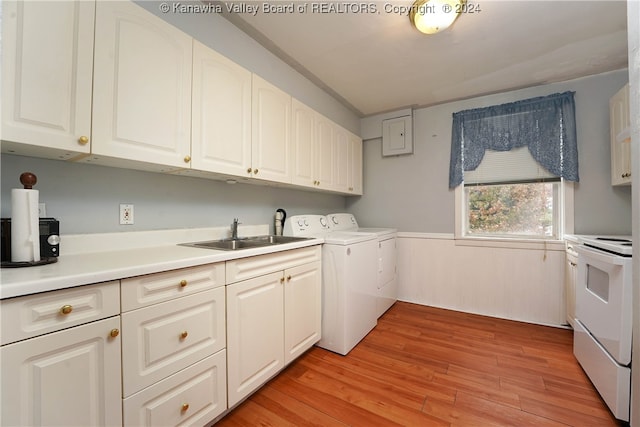 laundry room featuring washing machine and clothes dryer, sink, and light hardwood / wood-style flooring