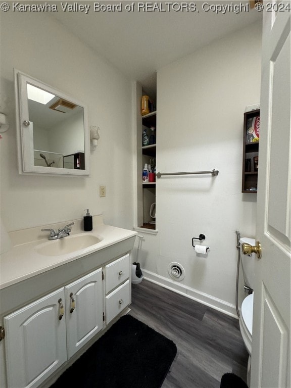 bathroom featuring wood-type flooring, vanity, and toilet