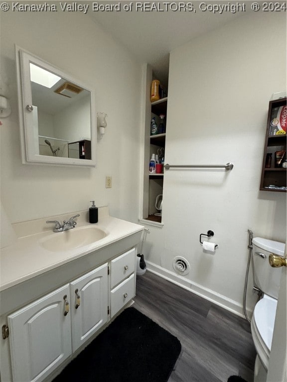 bathroom featuring wood-type flooring, vanity, and toilet