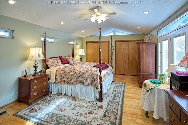 bedroom featuring a textured ceiling, ceiling fan, light hardwood / wood-style floors, and lofted ceiling