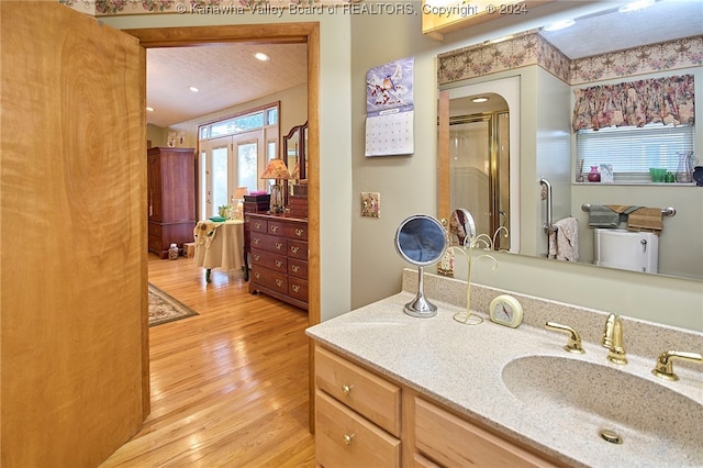 bathroom with french doors, hardwood / wood-style floors, an enclosed shower, a textured ceiling, and vanity