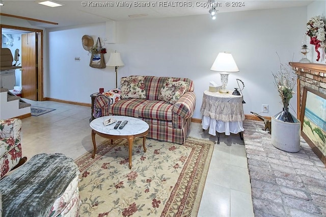 living room featuring a brick fireplace and light tile patterned floors