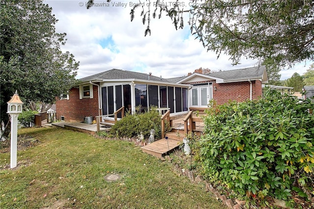 rear view of house featuring a sunroom and a yard