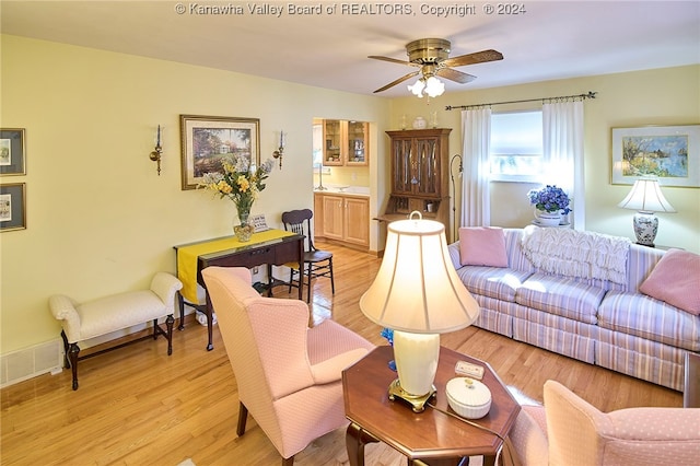 living room featuring ceiling fan and light hardwood / wood-style floors