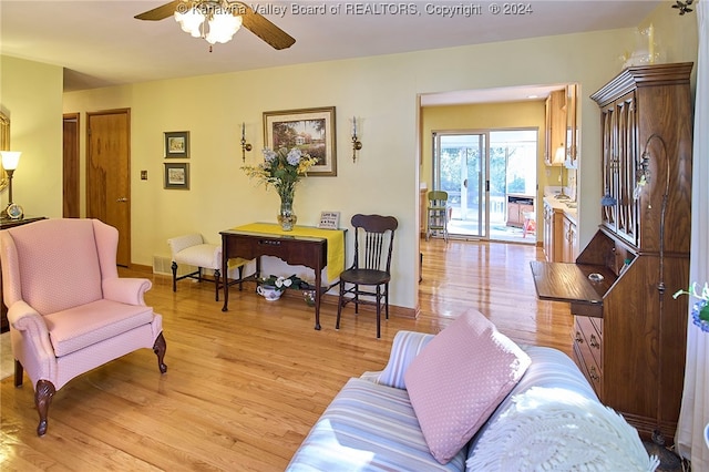 living room with ceiling fan and light hardwood / wood-style flooring