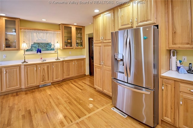 kitchen with stainless steel fridge and light hardwood / wood-style flooring