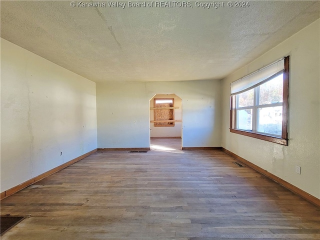 empty room featuring hardwood / wood-style floors and a textured ceiling