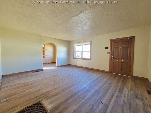 interior space with a textured ceiling and dark wood-type flooring