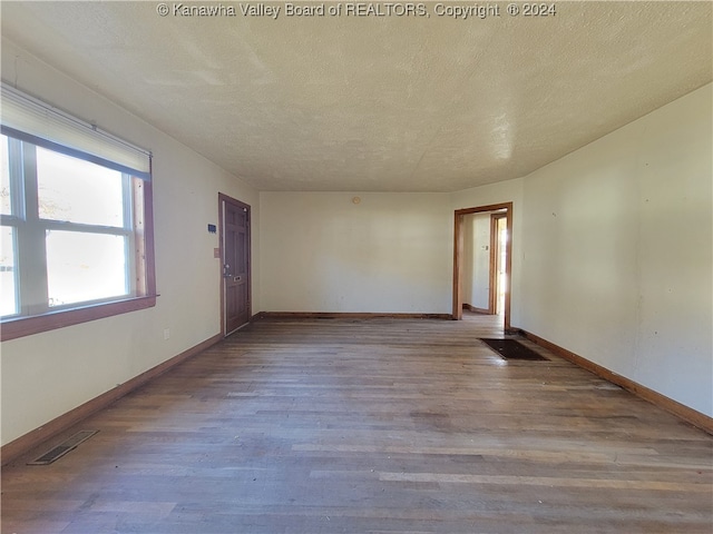 unfurnished room featuring hardwood / wood-style floors and a textured ceiling