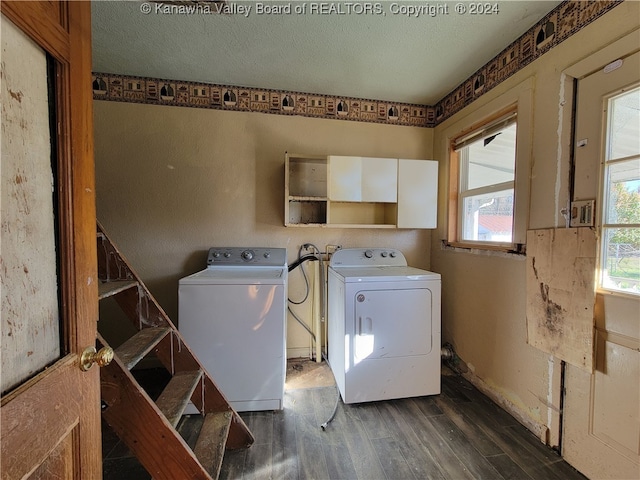 washroom with a textured ceiling, washing machine and dryer, and dark wood-type flooring