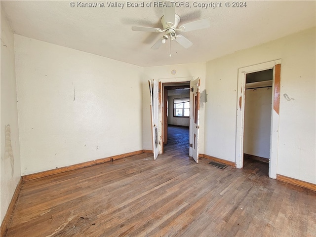 unfurnished bedroom with dark hardwood / wood-style flooring, a closet, and ceiling fan