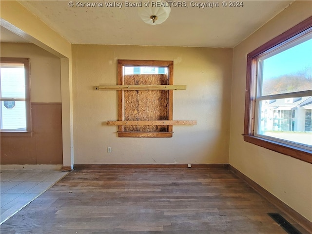 unfurnished room with hardwood / wood-style flooring and a wealth of natural light