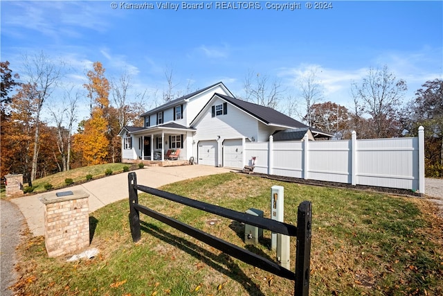 view of front of house featuring covered porch, a front yard, and a garage